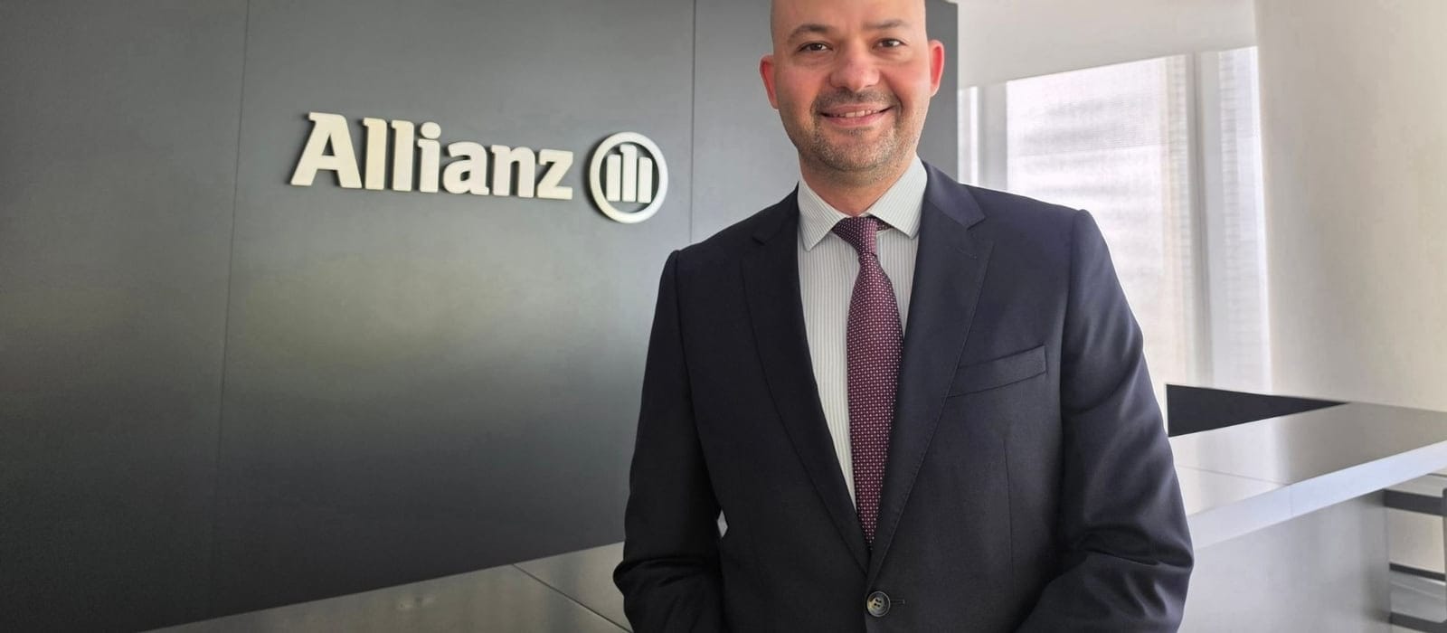 Allianz logolu duvar önünde Çağrı Sinmez'in portresi