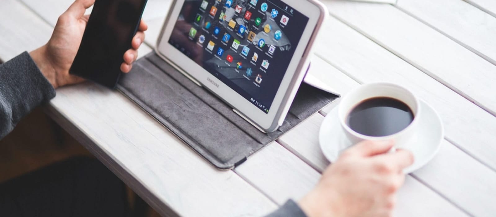 Kol saati takan bir kişinin iki eliyle akıllı telefon ekranına dokunması