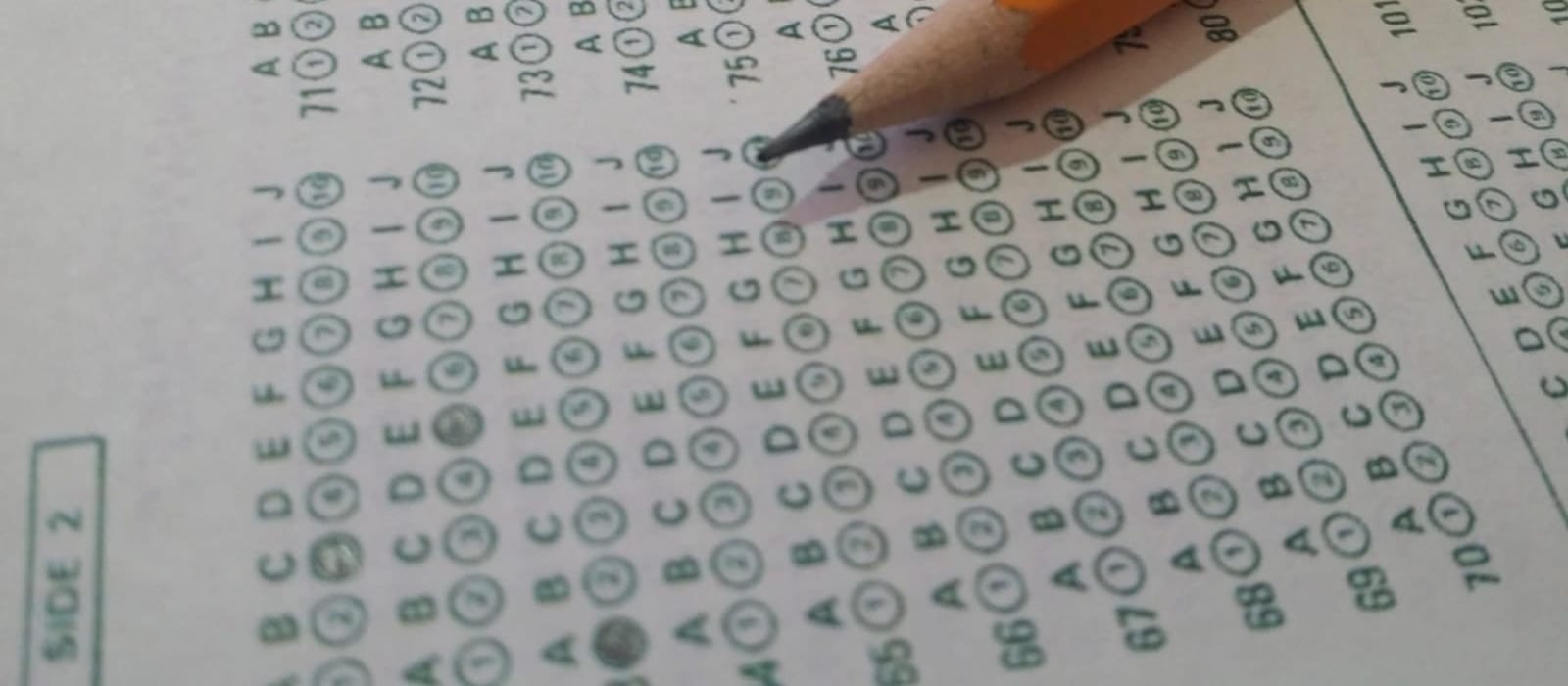 Optik cevap kâğıdındaki numaralı işaretleme dairelerinin üzerinde duran kurşun kalem