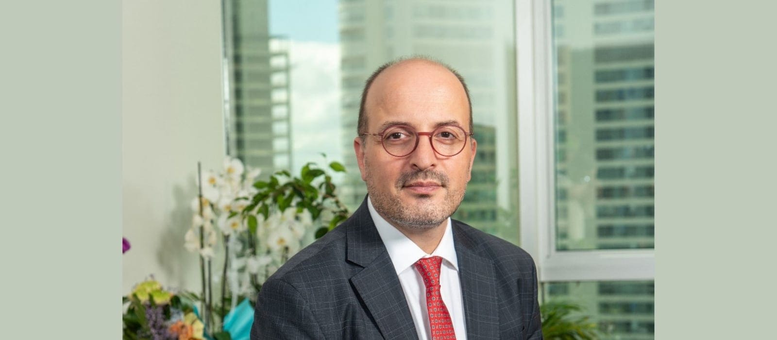 Ofiste bilgisayar ekranındaki yükselen finansal grafik çizgilerini inceleyen kişi